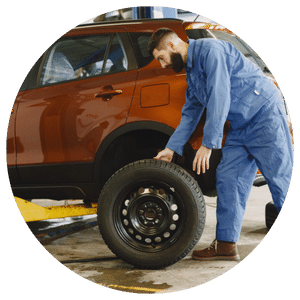 technician changing a tire on a car