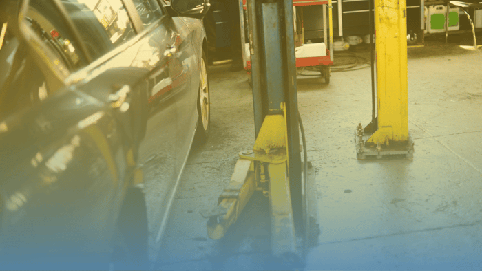 car next to lift in auto repair shop