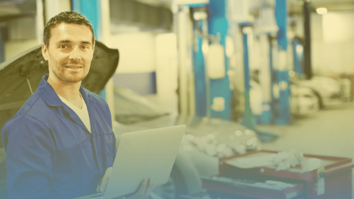 technician holding laptop in a shop